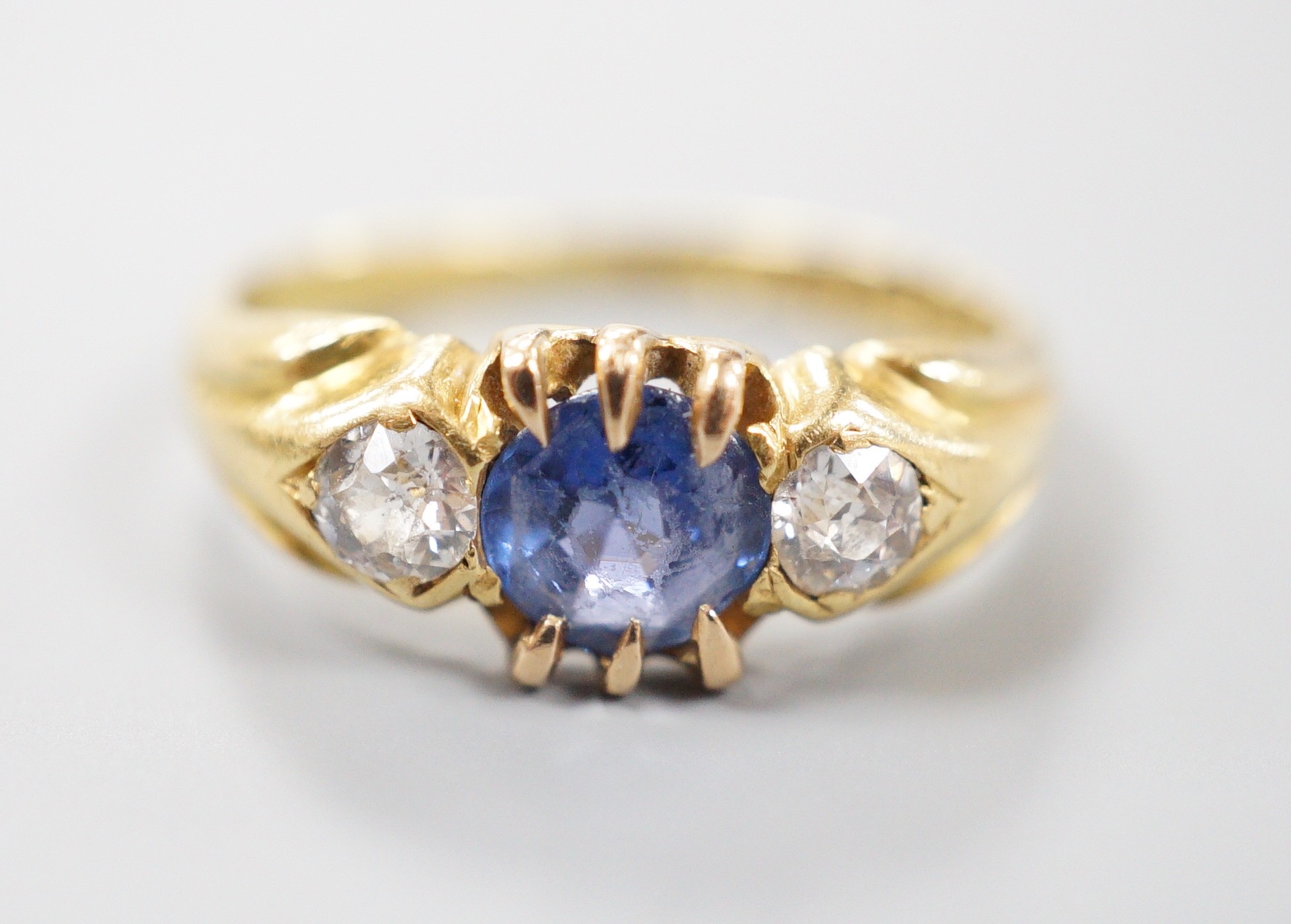 A late Victorian 18ct gold, sapphire and diamond set three stone ring, size I, gross weight 3 grams.